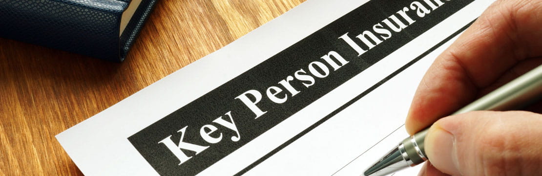 A person filling out a form titled "Key Person Insurance".